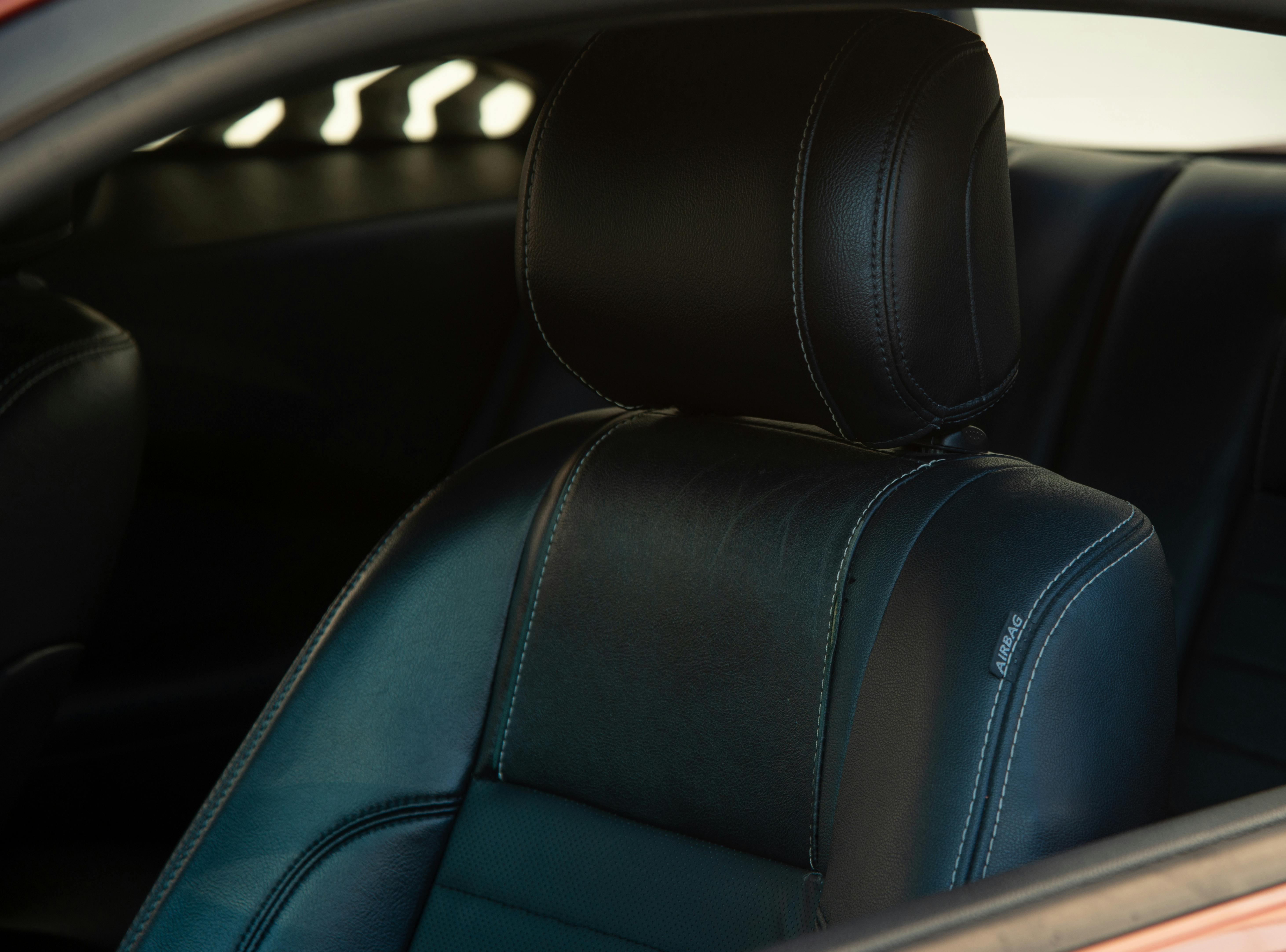 Black leather car seat with hand-stitched bolster